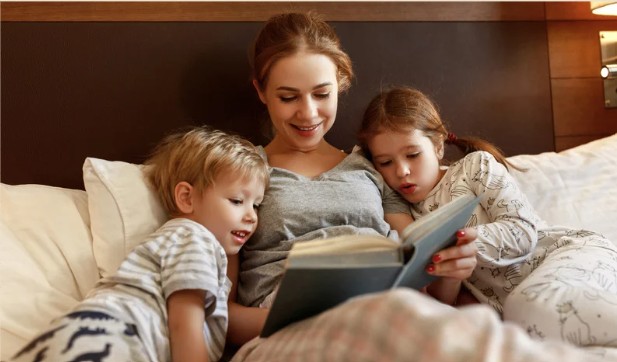 A mother reading a bedtime story to her two children